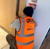 Global Facilities Inspector repairing a fire door
